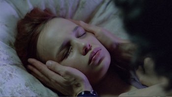 Movie still from “Christiane F.” (1981), directed by Uli Edel – A woman laying in bed with her eyes closed; Close Up shot, High angle