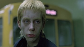 Movie still from “Christiane F.” (1981), directed by Uli Edel – A young boy with blonde hair and blue eyes; Close Up shot, High angle