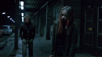 Movie still from “Christiane F.” (1981), directed by Uli Edel – A woman with red hair standing next to a man; Medium shot, Over the shoulder angle