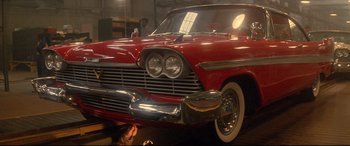 Movie still from “Christine” (1983), directed by John Carpenter – An old red car is parked in a garage; Wide shot, Low angle