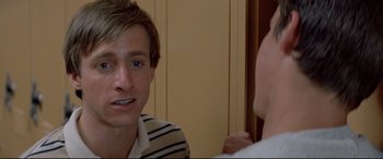 Movie still from “Christine” (1983), directed by John Carpenter – A man is talking to another man in front of a mirror; Close Up shot, Over the shoulder angle