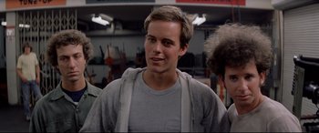 Movie still from “Christine” (1983), directed by John Carpenter – A young man in a gray shirt is smiling for the camera; Close Up shot, Low angle