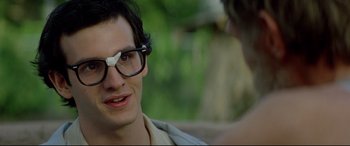 Movie still from “Christine” (1983), directed by John Carpenter – A young man wearing glasses talking to another man; Close Up shot, Over the shoulder angle