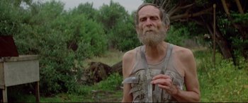 Movie still from “Christine” (1983), directed by John Carpenter – An old man with a long beard is standing in the woods; Close Up shot, Low angle