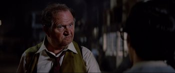 Movie still from “Christine” (1983), directed by John Carpenter – An older man in a vest and tie looking to his left; Close Up shot, Low angle