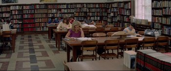 Movie still from “Christine” (1983), directed by John Carpenter – A group of people sitting at tables in a library; Wide shot, High angle