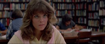 Movie still from “Christine” (1983), directed by John Carpenter – A young woman with long hair sitting in a library; Close Up shot, Low angle