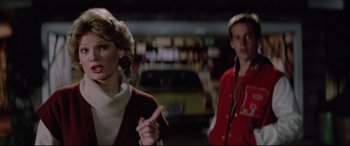 Movie still from “Christine” (1983), directed by John Carpenter – A man and a woman are standing next to each other; Medium shot, Over the shoulder angle