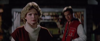 Movie still from “Christine” (1983), directed by John Carpenter – A woman and a man standing next to each other in a room; Close Up shot, Over the shoulder angle