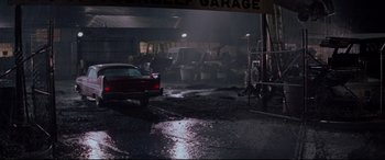 Movie still from “Christine” (1983), directed by John Carpenter – A car is parked in a garage in the rain; Extreme Wide shot, High angle