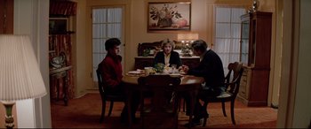 Movie still from “Christine” (1983), directed by John Carpenter – A group of people sitting around a table eating food; Wide shot, High angle