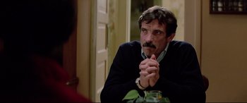 Movie still from “Christine” (1983), directed by John Carpenter – A person sitting at a table; Close Up shot, Over the shoulder angle