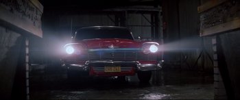 Movie still from “Christine” (1983), directed by John Carpenter – A car that is parked in a garage; Wide shot, Low angle