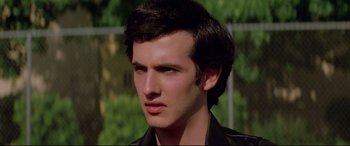 Movie still from “Christine” (1983), directed by John Carpenter – A young man with a black leather jacket; Close Up shot, Low angle