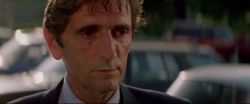 Movie still from “Christine” (1983), directed by John Carpenter – A person wearing a suit and tie; Close Up shot, Low angle