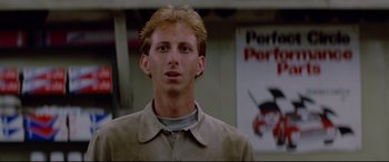 Movie still from “Christine” (1983), directed by John Carpenter – A man with blonde hair is looking at the camera; Close Up shot, Low angle