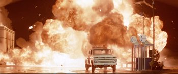 Movie still from “Christine” (1983), directed by John Carpenter – An old truck is driving through a cloud of smoke; Wide shot, Low angle