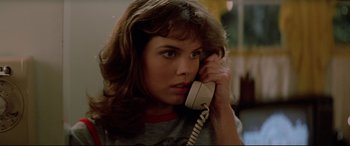 Movie still from “Christine” (1983), directed by John Carpenter – A woman holding a phone up to her ear; Close Up shot, Low angle