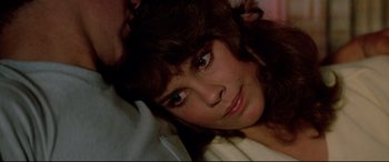 Movie still from “Christine” (1983), directed by John Carpenter – A woman's face as she lays on a bed; Close Up shot, High angle
