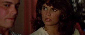 Movie still from “Christine” (1983), directed by John Carpenter – A person wearing a white shirt; Close Up shot, Over the shoulder angle