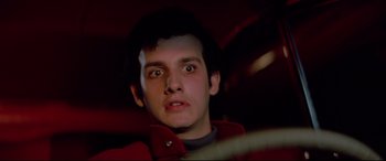 Movie still from “Christine” (1983), directed by John Carpenter – A young man in a red jacket stares at the camera; Close Up shot, Low angle