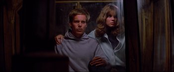 Movie still from “Christine” (1983), directed by John Carpenter – A man and a woman standing next to each other; Medium shot, Low angle