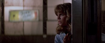 Movie still from “Christine” (1983), directed by John Carpenter – A woman standing next to a wall in a room; Close Up shot, Over the shoulder angle
