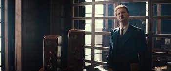 Movie still from “Christopher Robin” (2018), directed by Marc Forster – A man standing in front of two suitcases in front of a window; Medium shot, Low angle