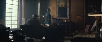 Movie still from “Christopher Robin” (2018), directed by Marc Forster – A man in a suit standing in front of a painting; Wide shot, Low angle