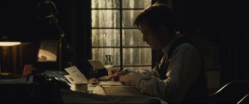 Movie still from “Christopher Robin” (2018), directed by Marc Forster – A man sitting at a table writing on a piece of paper; Medium shot, Low angle