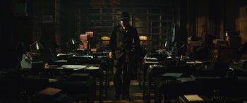 Movie still from “Christopher Robin” (2018), directed by Marc Forster – A man in a suit and hat standing in front of a desk; Wide shot, Low angle