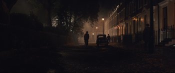 Movie still from “Christopher Robin” (2018), directed by Marc Forster – Two people walking down a street at night; Extreme Wide shot, Over the shoulder angle
