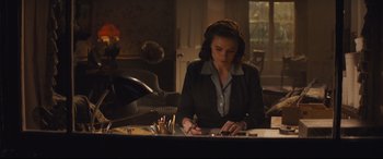 Movie still from “Christopher Robin” (2018), directed by Marc Forster – A woman sitting at a table writing on a piece of paper; Medium shot, High angle