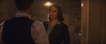Movie still from “Christopher Robin” (2018), directed by Marc Forster – A woman standing in front of a man in a room; Medium shot, Over the shoulder angle