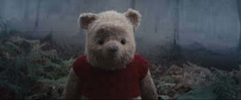 Movie still from “Christopher Robin” (2018), directed by Marc Forster – A teddy bear wearing a red sweater in a forest; Close Up shot, Low angle
