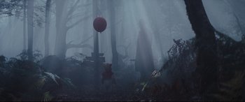 Movie still from “Christopher Robin” (2018), directed by Marc Forster – A person and a bear in the woods with a red balloon; Wide shot, Low angle