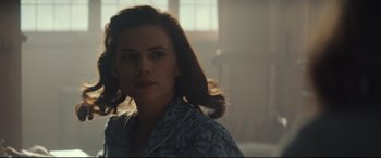 Movie still from “Christopher Robin” (2018), directed by Marc Forster – A woman in a blue shirt is standing in a room; Close Up shot, Over the shoulder angle