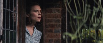 Movie still from “Christopher Robin” (2018), directed by Marc Forster – A woman standing in front of a brick wall; Medium shot, Low angle