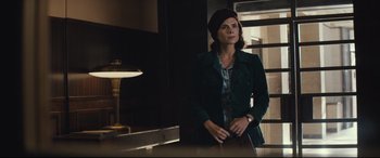 Movie still from “Christopher Robin” (2018), directed by Marc Forster – A woman standing in front of a lamp in a dark room; Medium shot, Low angle