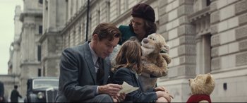 Movie still from “Christopher Robin” (2018), directed by Marc Forster – A group of people sitting on the side of a building; Medium shot, Low angle