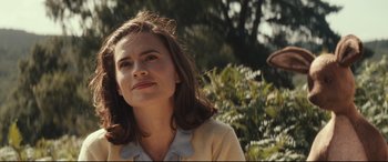 Movie still from “Christopher Robin” (2018), directed by Marc Forster – A woman in a yellow shirt is looking at the camera; Close Up shot, Over the shoulder angle
