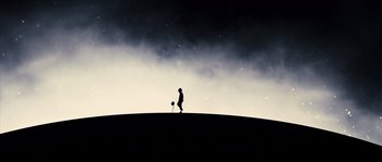 Movie still from “Chrysalis” (2007), directed by Julien Leclercq – A person standing on top of a hill holding a frisbee; Extreme Wide shot, Low angle