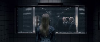 Movie still from “Chrysalis” (2007), directed by Julien Leclercq – A woman standing in front of a group of people; Medium shot, Over the shoulder angle