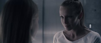 Movie still from “Chrysalis” (2007), directed by Julien Leclercq – A woman looking into a mirror while standing next to another woman; Close Up shot, Over the shoulder angle
