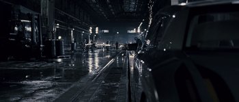 Movie still from “Chrysalis” (2007), directed by Julien Leclercq – A car is parked in a parking lot in the rain; Extreme Wide shot, High angle