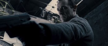 Movie still from “Chrysalis” (2007), directed by Julien Leclercq – A person with a gun in his hand; Close Up shot, Low angle