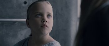 Movie still from “Chrysalis” (2007), directed by Julien Leclercq – A little girl with blue eyes looking up at the sky; Close Up shot, Over the shoulder angle