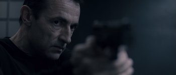 Movie still from “Chrysalis” (2007), directed by Julien Leclercq – A person holding a gun; Close Up shot, Low angle