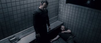 Movie still from “Chrysalis” (2007), directed by Julien Leclercq – Two men in black clothes are in a bathroom; Medium shot, High angle