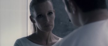 Movie still from “Chrysalis” (2007), directed by Julien Leclercq – A woman looking into a mirror while standing next to a man; Close Up shot, Over the shoulder angle